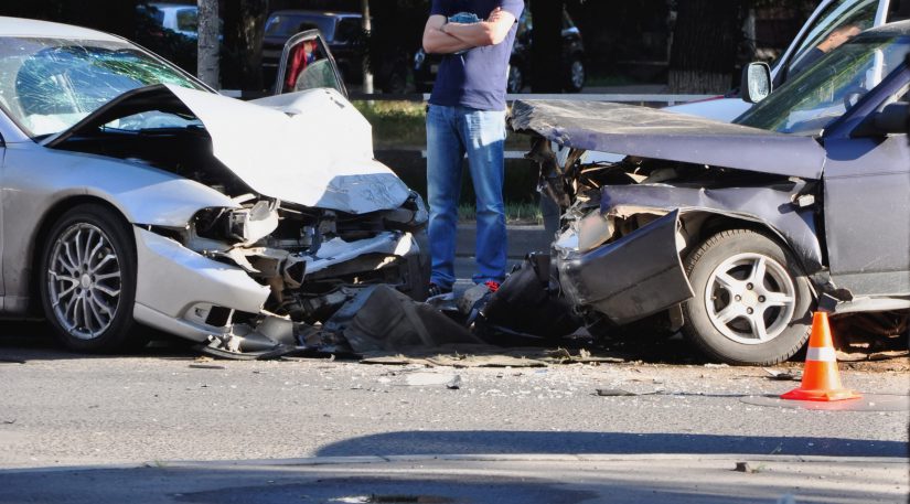 Photo of Man Standing Between Two Crashed Cars